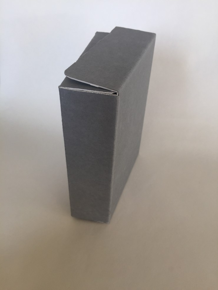 Image of a clamshell or drop spine box made from corrugated board positioned upright