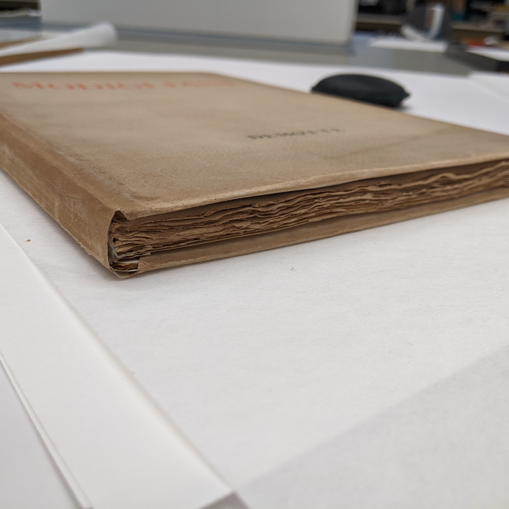 The image shows a view of the finished book from the bottom edge. You can see the rough cut edges of the books pages and the newly repaired dust jacket wrapped around the book.